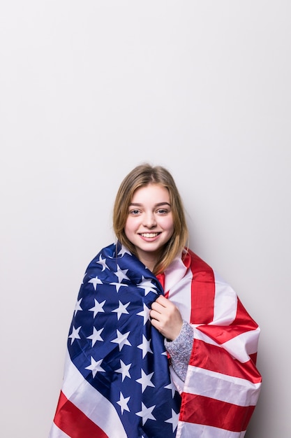 Chica estudiante sosteniendo una bandera americana aislada