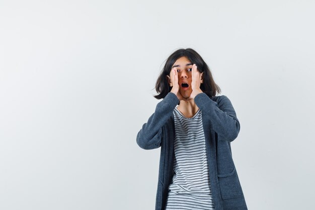 Una chica expresiva está posando en el estudio.