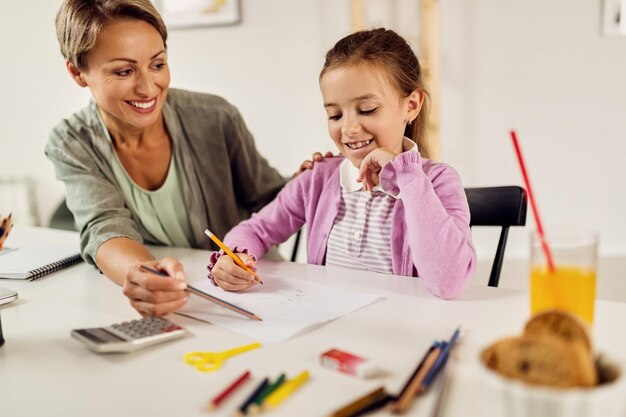 Chica feliz aprendiendo matemáticas con la ayuda de su madre en casa