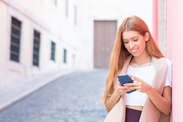 Chica feliz ciudad surfing net en smartphone