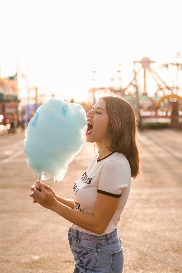 Foto gratuito chica feliz comiendo algodón de azúcar