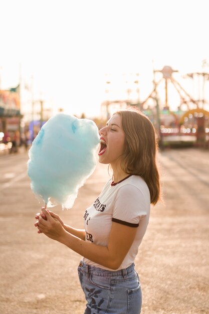 Chica feliz comiendo algodón de azúcar