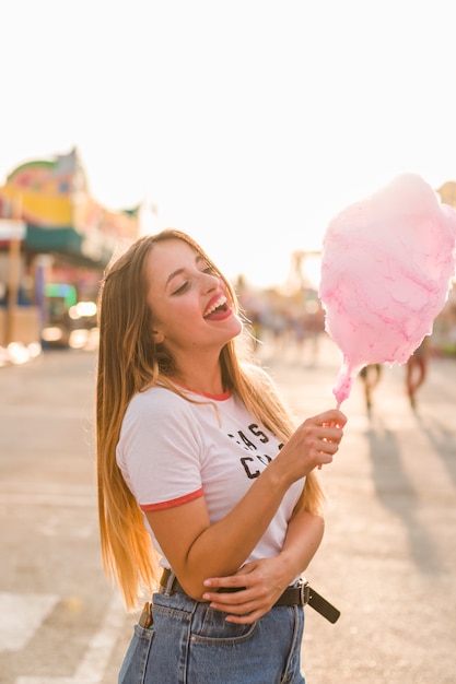 Chica feliz comiendo algodón de azúcar