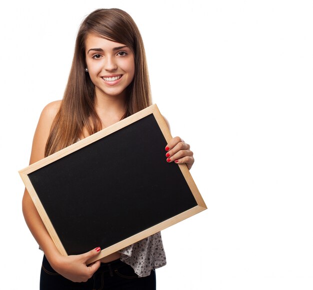 Chica feliz enseñando una pizarra pequeña