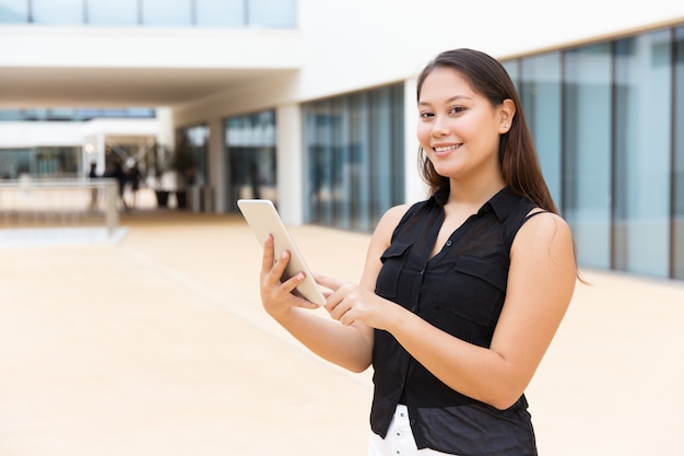 Chica feliz estudiante alegre con tableta sonriendo