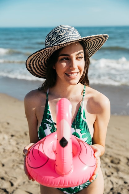 Chica feliz con flamingo inflable