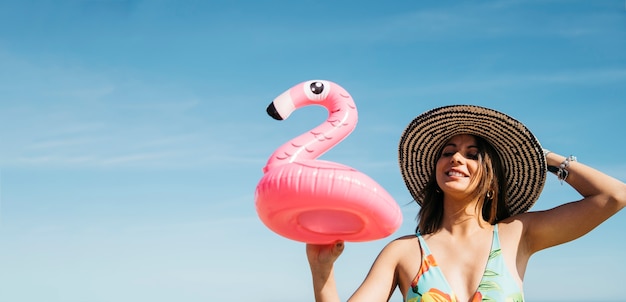 Chica feliz con flamingo inflable