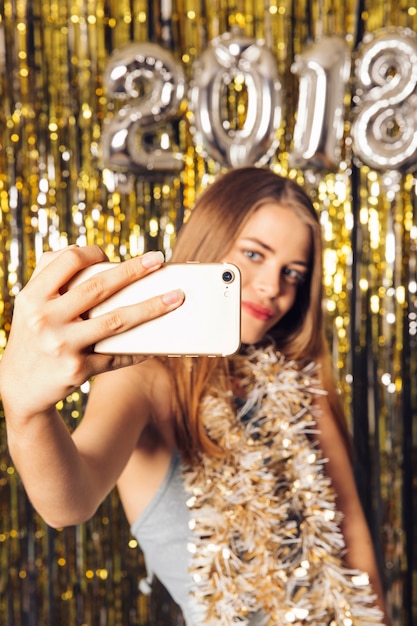 Chica feliz haciendo un selfie en fiesta de año nuevo