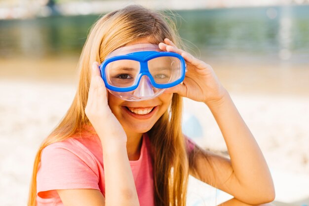 Chica feliz en máscara de buceo en la playa