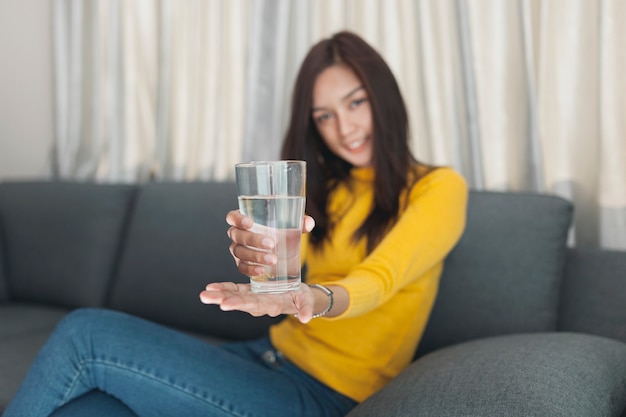 Foto gratuita chica feliz mostrando un vaso de agua