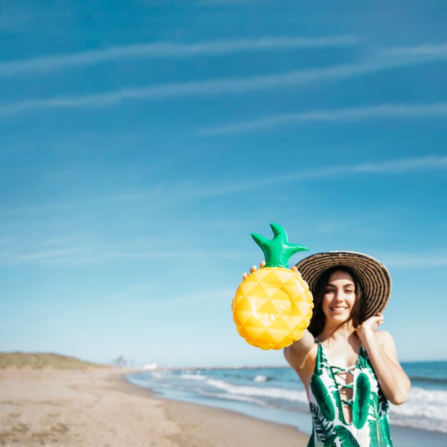 Chica feliz con piña inflable