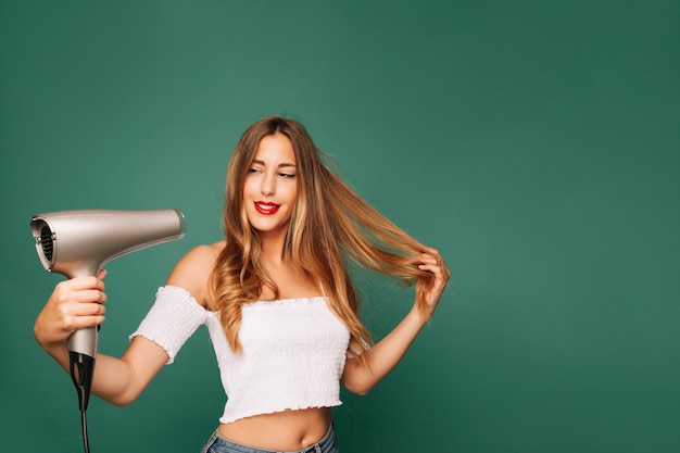 Foto gratuita chica feliz con secador de pelo