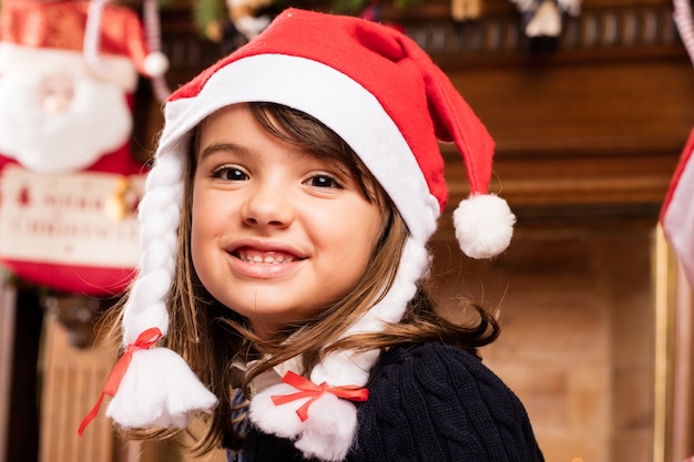 Chica feliz sentada en la sala de estar en navidad