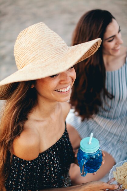 Chica feliz con sombrero en la playa