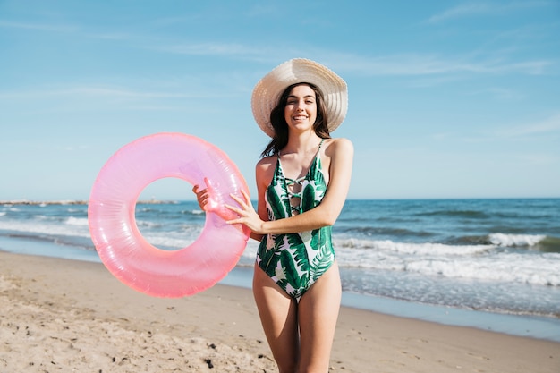 Chica feliz sujetando anillo inflable