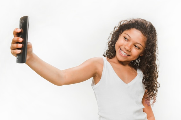 Chica feliz tomando selfie desde teléfono móvil