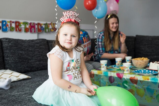 Chica en la fiesta de cumpleaños mirando a la cámara