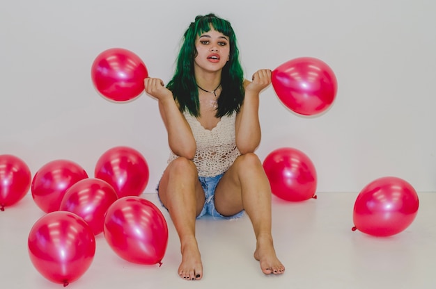 Chica de fiesta sosteniendo dos globos