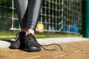 Foto gratuita chica fitness se encuentra en una pista con cordones desatados