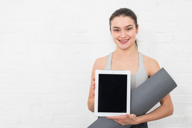 Chica fitness enseñando tablet