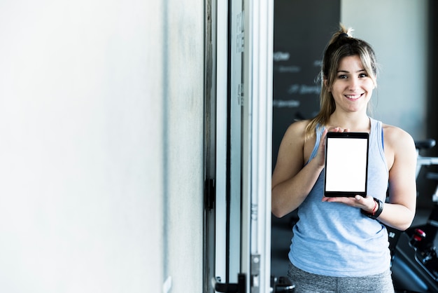 Chica fitness enseñando tablet,