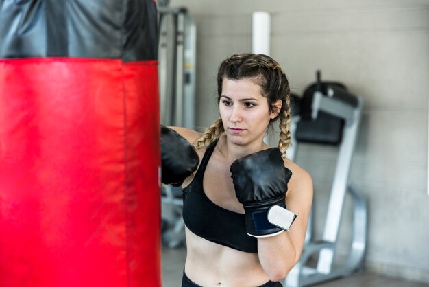Chica fitness golpeando saco de boxeo