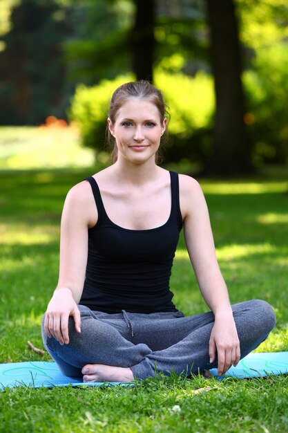 Chica fitness relajante después de hacer ejercicio en el parque