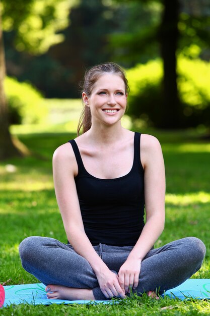 Chica fitness relajante después de hacer ejercicio en el parque