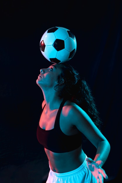 Chica en forma adulta haciendo trucos con pelota