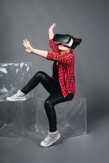 Chica con gafas de realidad virtual tocando sus manos en el aire