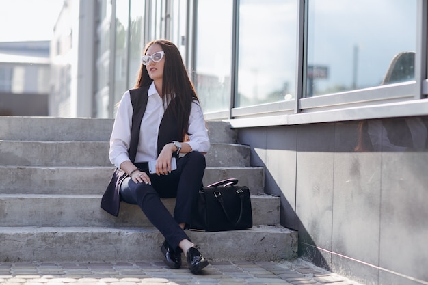 Chica con gafas sentada en unas escaleras