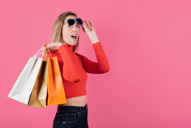 Chica con gafas de sol con bolsas de compras