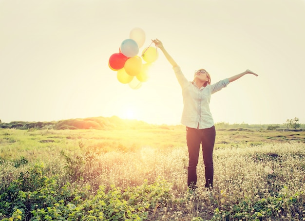 Foto gratuita chica con globos y los brazos extendidos