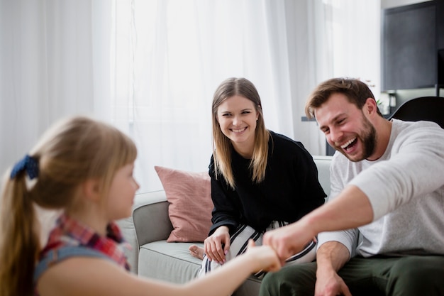 Chica golpeando los puños con los padres