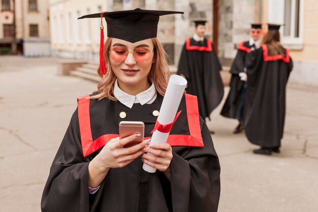 Chica graduada de alto ángulo con móvil