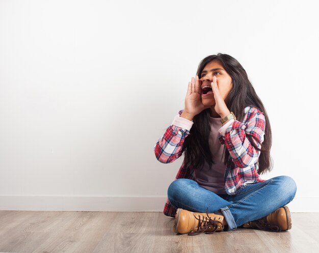 Chica gritando con las manos en la cara