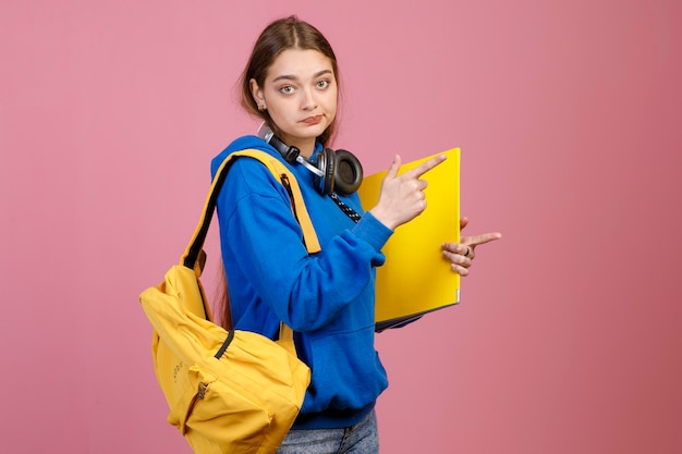 Chica guapa con auriculares de pie con mochila