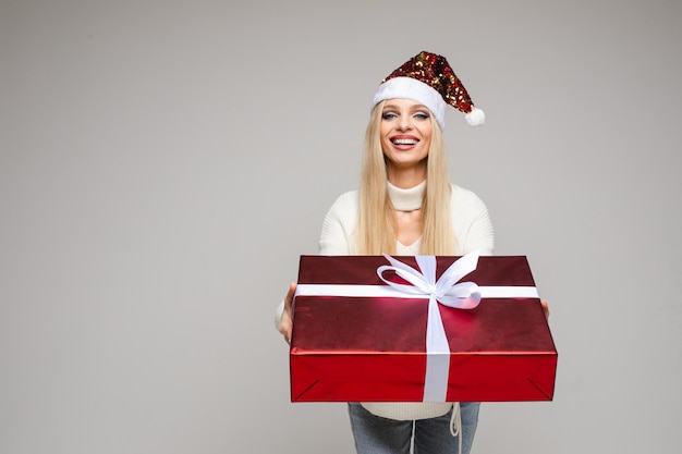 Chica guapa dando regalo de Navidad a la cámara.