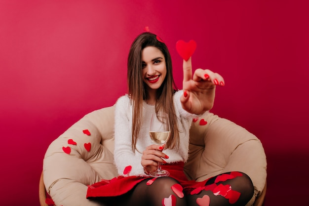 Chica guapa divirtiéndose en el día de San Valentín y jugando con confeti