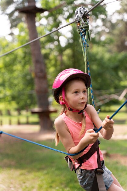 Chica guapa divirtiéndose en un parque de aventuras