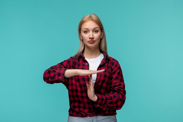 Chica guapa joven del día internacional de los estudiantes en camisa roja a cuadros que muestra la señal de stop