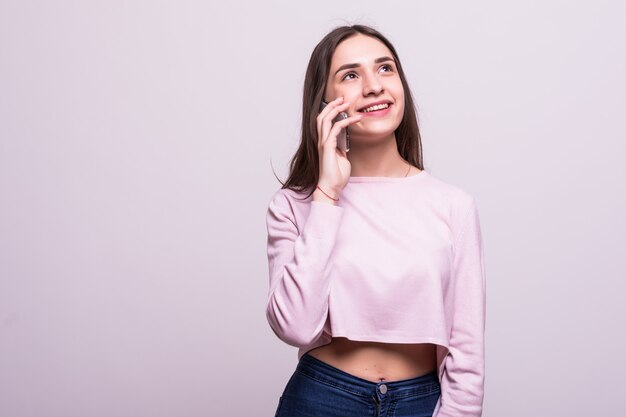 Chica guapa joven hablar teléfono aislado en blanco