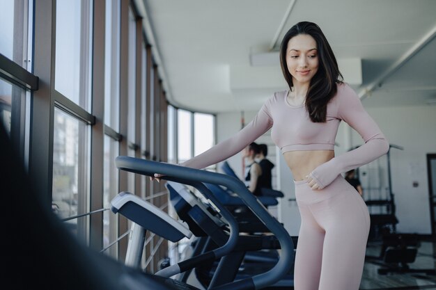 Chica guapa joven en ropa deportiva en el gimnasio