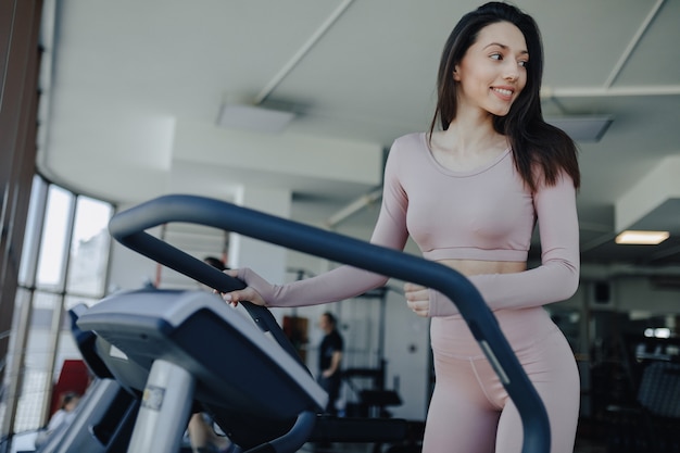 Chica guapa joven en ropa deportiva en el gimnasio