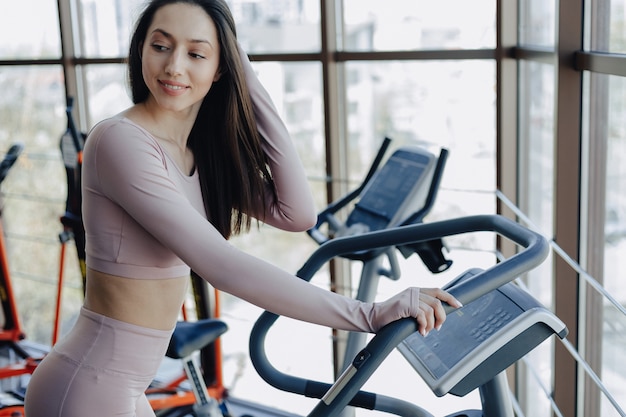 Chica guapa joven en ropa deportiva en el gimnasio