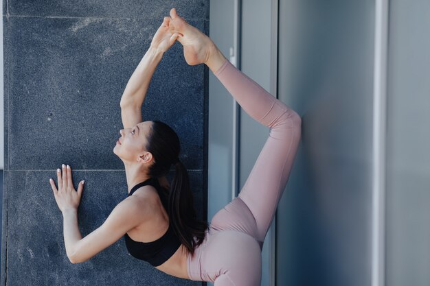 Chica guapa joven en ropa deportiva haciendo yoga