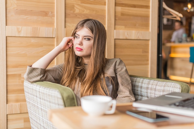 Chica guapa pasando la tarde en una cafetería