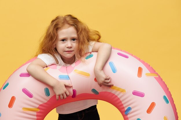 Chica guapa con pelo largo abrazando círculo de natación inflable