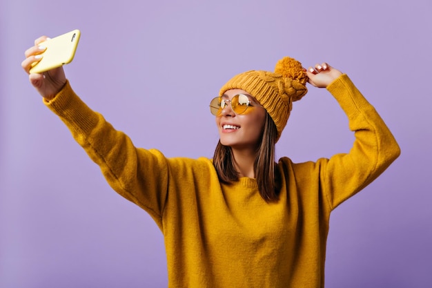 Chica guapa con ropa amarilla posa para una foto Retrato de modelo con largas pestañas con gafas de sol brillantes