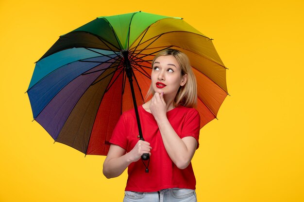 Chica guapa rubia del festival brasileño de Frevo mirando hacia el paraguas del arco iris